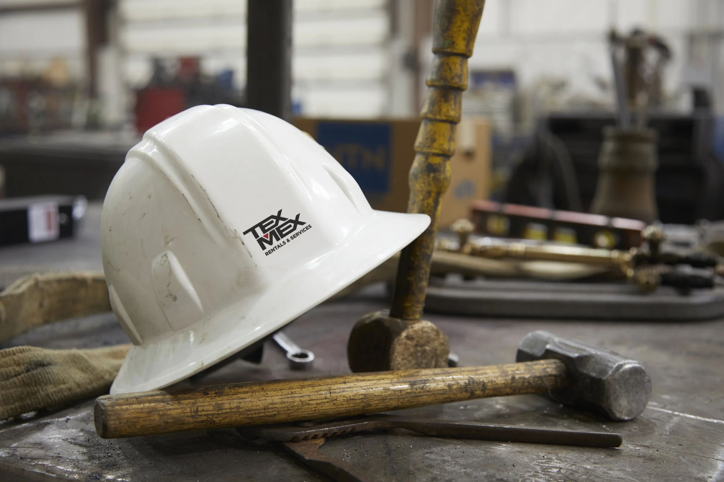 A TexMex hard hat resting among well-kept tools in the shop